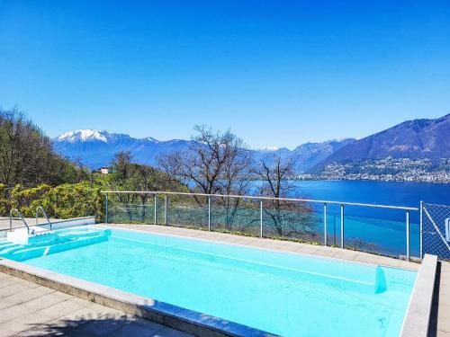 a swimming pool with a view of the water and mountains at Apartment Splendid Maggiore View by Interhome in Magadino