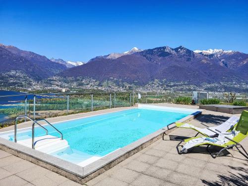 a swimming pool with two lawn chairs and a swimming pool at Apartment Splendid Maggiore View by Interhome in Magadino