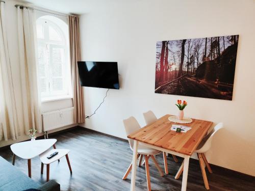 ゼープニッツにあるF1B - Urlaubsmagie - Helle Wohnung mit Sauna und Poolの木製のテーブルと椅子のあるリビングルーム