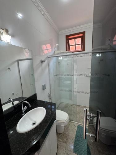 a bathroom with a shower and a sink and a toilet at Suíte privativa próximo a Pampulha in Belo Horizonte