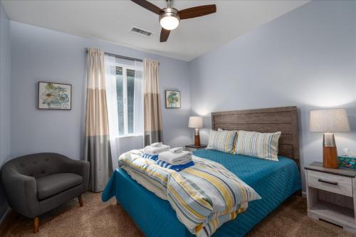 a bedroom with a blue bed and a chair at Hilltop Paradise with stunning views/hot tub/firepit/dog friendly in Oakhurst