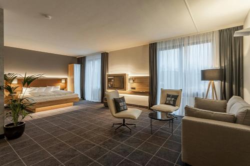 a hotel room with a bed and a couch at Four Points Flex by Sheraton Ratingen Düsseldorf Airport in Ratingen