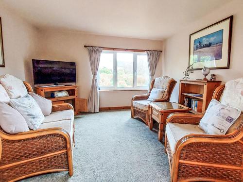 a living room with three chairs and a television at Chalet Skye Garden Accommodation by Interhome in Portree