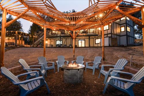 a patio with chairs and a fire pit in front of a house at Greystone Manor- HUGE home with sleeping for 21 in Oakhurst