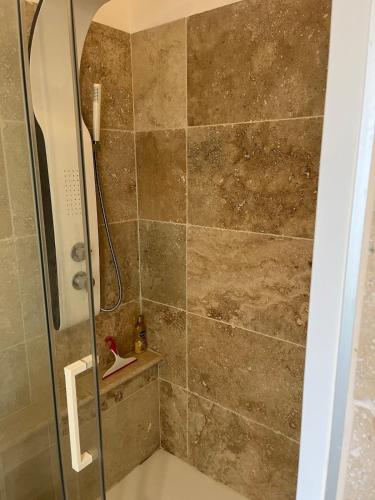 une douche avec une porte vitrée dans une salle de bain dans l'établissement Appartement Cavalaire sur Mer, à Cavalaire-sur-Mer