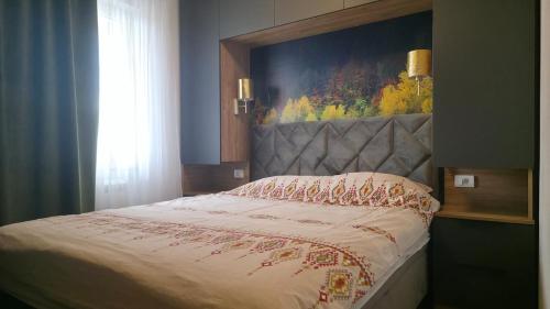 a bedroom with a bed with a painting on the wall at Modern Luxury Apartment & Free Parking in Donje Mladice