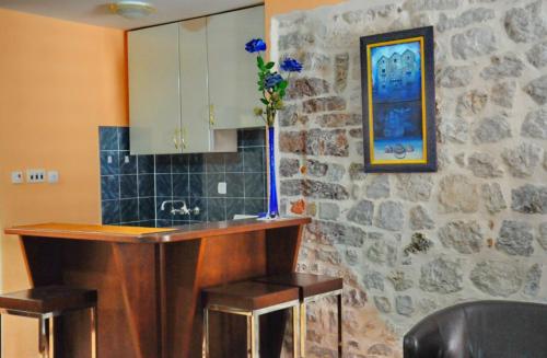 a kitchen with a sink and a counter with stools at Apartments Parteli in Kotor