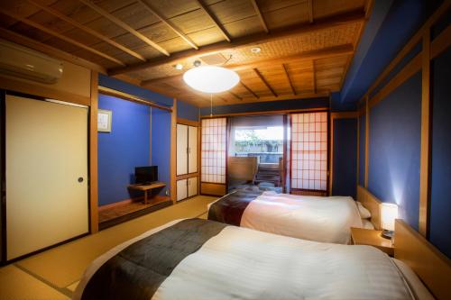 two beds in a room with blue walls at Yuyaruru Saisai in Kanazawa