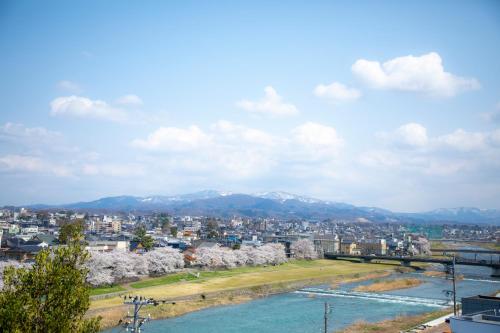 a view of a city with a river and mountains at Yuyaruru Saisai in Kanazawa
