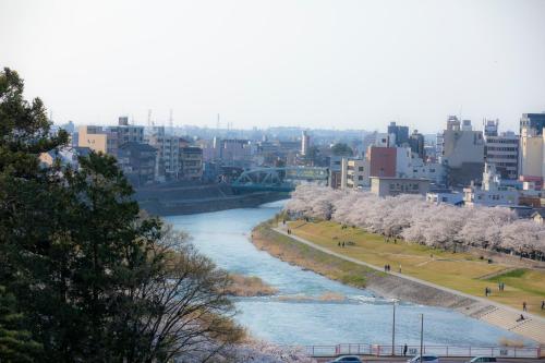 a view of a river in a city with white trees at Yuyaruru Saisai in Kanazawa