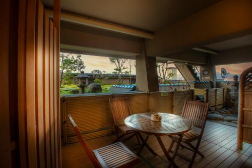 a table and chairs on a balcony with a table at Yuyaruru Saisai in Kanazawa