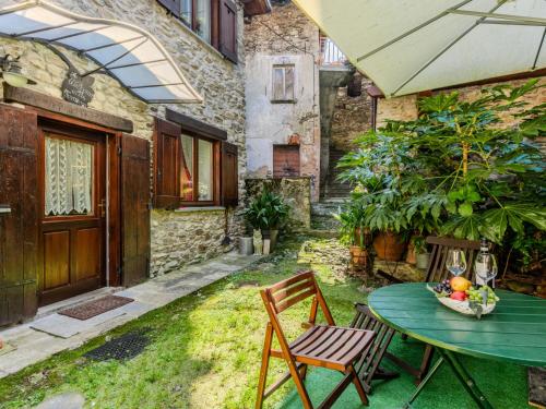 Un patio con una mesa y sillas y una sombrilla. en Apartment Alla Fontana by Interhome, en Domaso