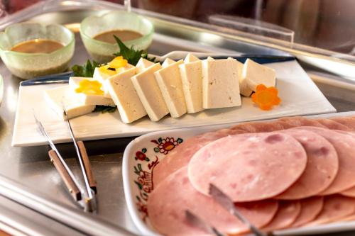 two plates of food on a tray with meats and cheese at Yuyaruru Saisai in Kanazawa