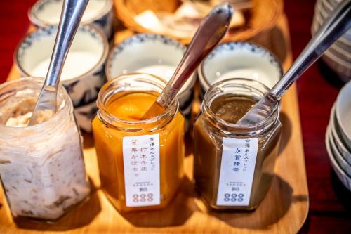 a wooden tray with three jars of honey and spoons at Yuyaruru Saisai in Kanazawa
