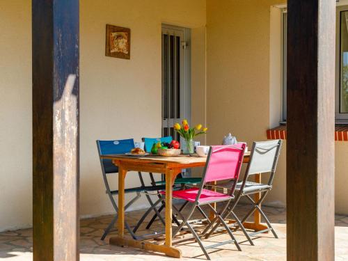 ein Holztisch mit vier Stühlen um ihn herum in der Unterkunft Holiday Home L'Oiseau Bleu by Interhome in La Plaine-sur-Mer