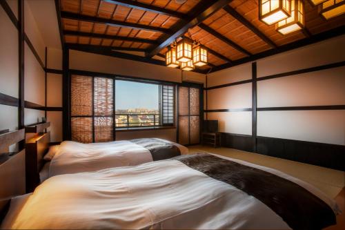 two beds in a room with a window at Yuyaruru Saisai in Kanazawa