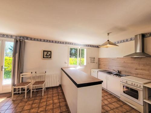 kuchnia z białymi urządzeniami oraz stołem i krzesłami w obiekcie Holiday Home Le Large by Interhome w mieście Saint-Philibert