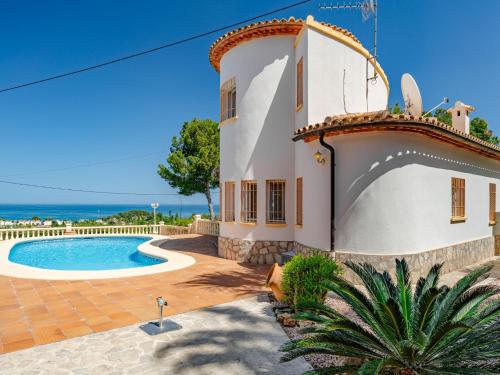 a house with a swimming pool next to the ocean at Villa Villa Rosa by Interhome in Denia