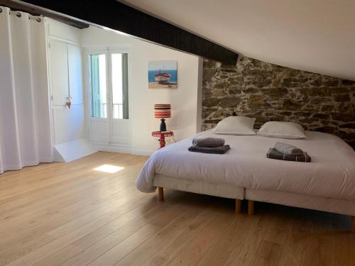 una camera da letto con un letto e un muro di pietra di DUPLEX REP 10 COEUR de COLLIOURE avec parking proche a Collioure