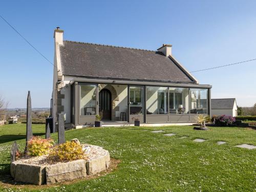une maison avec une grande fenêtre sur une pelouse verdoyante dans l'établissement Holiday Home Doux Repos by Interhome, à Guimaëc