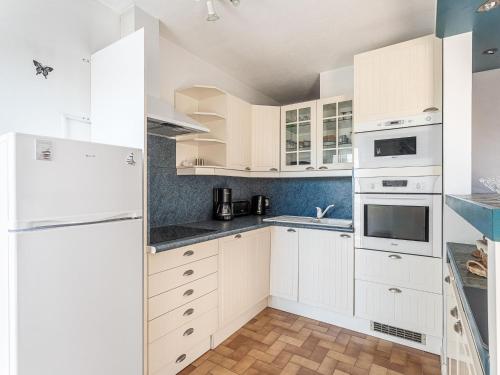 une cuisine blanche avec des armoires et des appareils blancs dans l'établissement Apartment Les Lavandes by Interhome, au Pradet