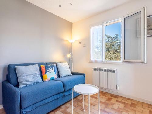 un salon avec un canapé bleu et une table dans l'établissement Apartment Les Lavandes by Interhome, au Pradet