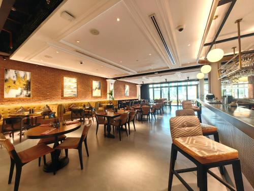 a restaurant with tables and chairs and a bar at Millennium Airport Hotel Dubai in Dubai