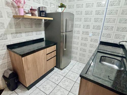 a kitchen with a refrigerator and a sink at Casa em Curitiba perto da Pedreira e Opera de Arame, com Ar Condicionado 3Quartos in Curitiba