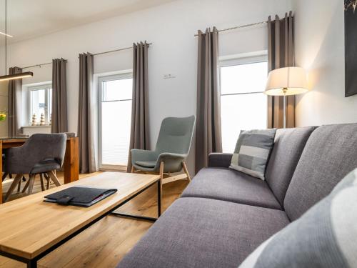 un salon avec un canapé, une table et des chaises dans l'établissement Apartment Bergblick Deluxe by Interhome, à Altenmarkt im Pongau