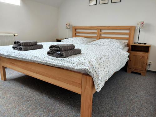 a bedroom with a bed with towels on it at Penzion Grado Davle in Davle