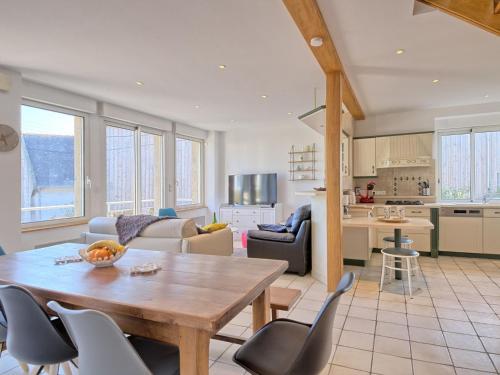 Il dispose d'une cuisine et d'un salon avec une table et des chaises en bois. dans l'établissement Holiday Home Trozoul by Interhome, à Trébeurden