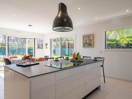 d'une cuisine avec des placards blancs et un plafond noir. dans l'établissement Holiday Home Keryanne by Interhome, à Plomelin