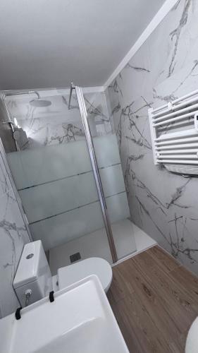 a white bathroom with a toilet and a sink at La baie de Rose in Roses