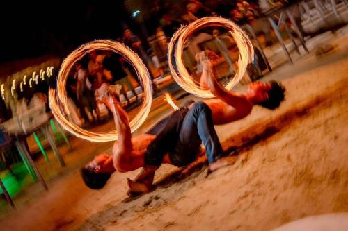 two men are playing with hula hoops in the sand at Golden Tulip Pattaya Beachfront Resort in North Pattaya