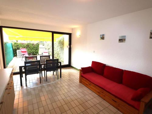 un salon avec un canapé rouge et une table dans l'établissement Charmant T2 Cabine climatisé avec terrasse, parking à 100m de la plage - FR-1-307-111, au Grau-du-Roi