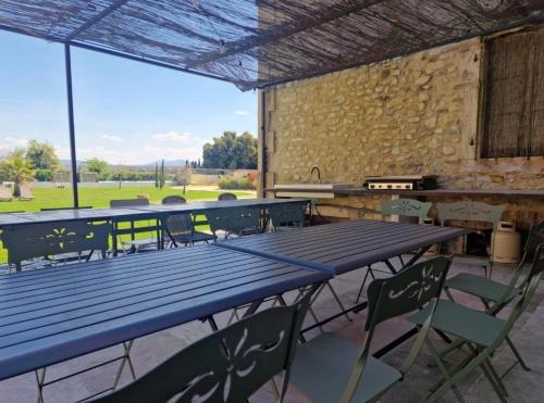 une grande table de pique-nique avec des chaises et un grill dans l'établissement Jolie Masdame un espace incroyable, à Sauzet