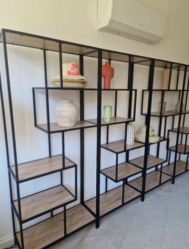 une étagère avec des étagères et des vases en bois dans l'établissement Jolie Masdame un espace incroyable, à Sauzet