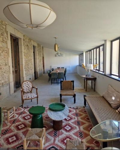 un salon avec un canapé, des chaises et une table dans l'établissement Jolie Masdame un espace incroyable, à Sauzet