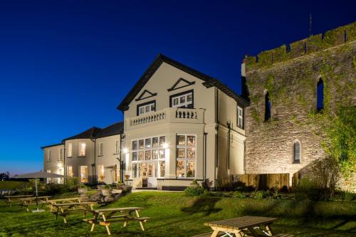 a building with picnic tables in front of it at The Castle Of Brecon Hotel, Brecon, Powys - The Coaching Inn Group in Brecon