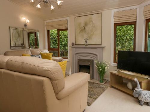 a living room with a couch and a television at Herdwick Lodge in Windermere