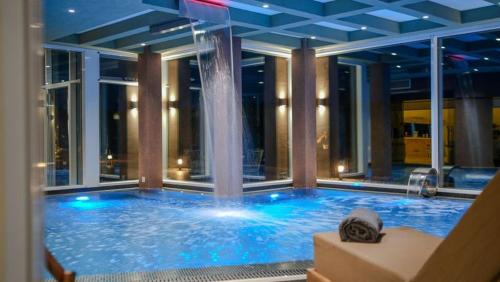 a large swimming pool with a fountain in a building at GF Luxury Villa with indoor pool -Afytos in Afitos