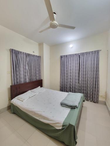 a bedroom with a bed and a ceiling fan at Two Bed Apartment by Dhaka Airport Terminal 3 in Dhaka