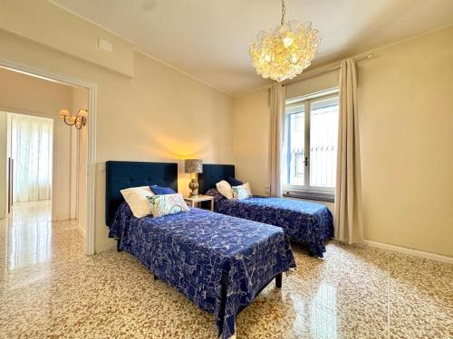 ein Schlafzimmer mit zwei Betten und einem Kronleuchter in der Unterkunft Falz 1 Family Apartments - Carraro Immobiliare Jesolo in Lido di Jesolo