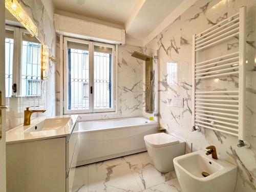 ein Badezimmer mit Badewanne, Waschbecken und Toilette in der Unterkunft Falz 1 Family Apartments - Carraro Immobiliare Jesolo in Lido di Jesolo