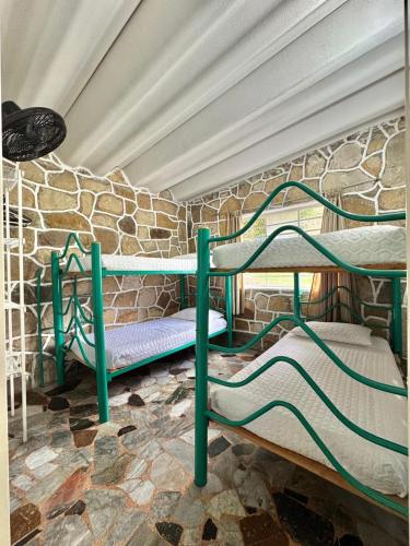 two bunk beds in a room with a stone wall at Cabañas El Itali in Fusagasuga