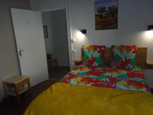 - une chambre avec un lit doté d'un couvre-lit coloré dans l'établissement La MUSARDIERE Gîte paisible à la campagne, à Goussaincourt