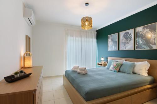 Un dormitorio con una cama azul y un escritorio. en Apartamento T2 Rio E Mar, en Vila Real de Santo António