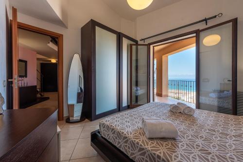 a bedroom with a bed with a view of the ocean at Moderno Appartamento in Cefalù