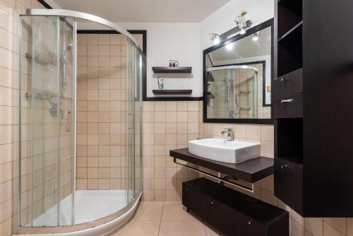 a bathroom with a glass shower and a sink at Moderno Appartamento in Cefalù