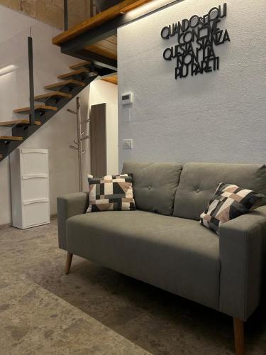 a couch in a living room with a staircase at Maison De Mammà in Altamura